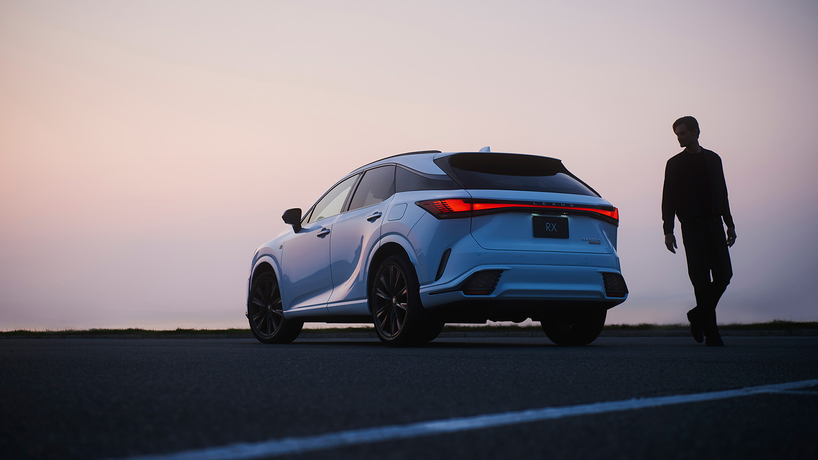 Trasera del Lexus RX destacando sus luces en carretera