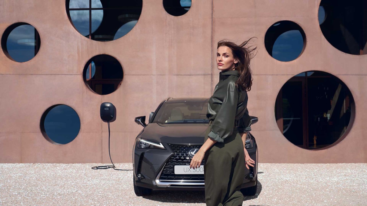 A Lexus UX 300e plugged into a charging wallbox