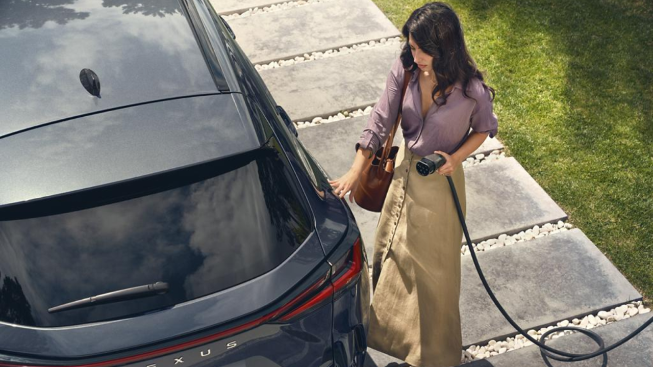 A person plugging in a charging socket into a Lexus NX 