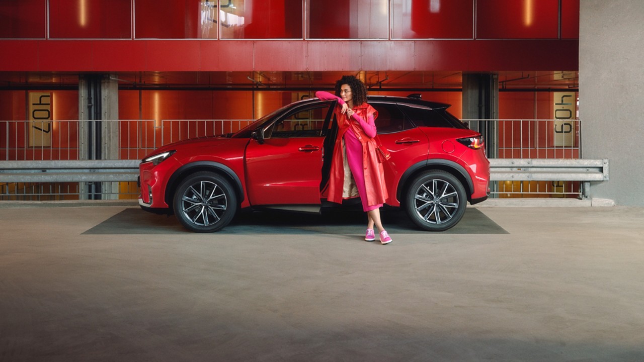A women standing next to a parked Lexus LBX