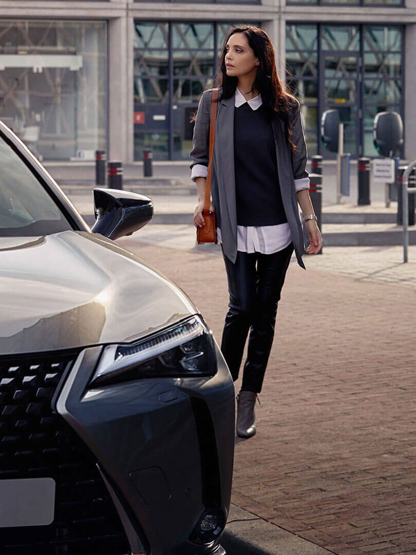 A person stood next to a Lexus
